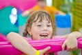 Portrait of a small beautiful girl in the play area of Ã¢â¬â¹Ã¢â¬â¹a children`s entertainment center. A happy child pulls himself up on